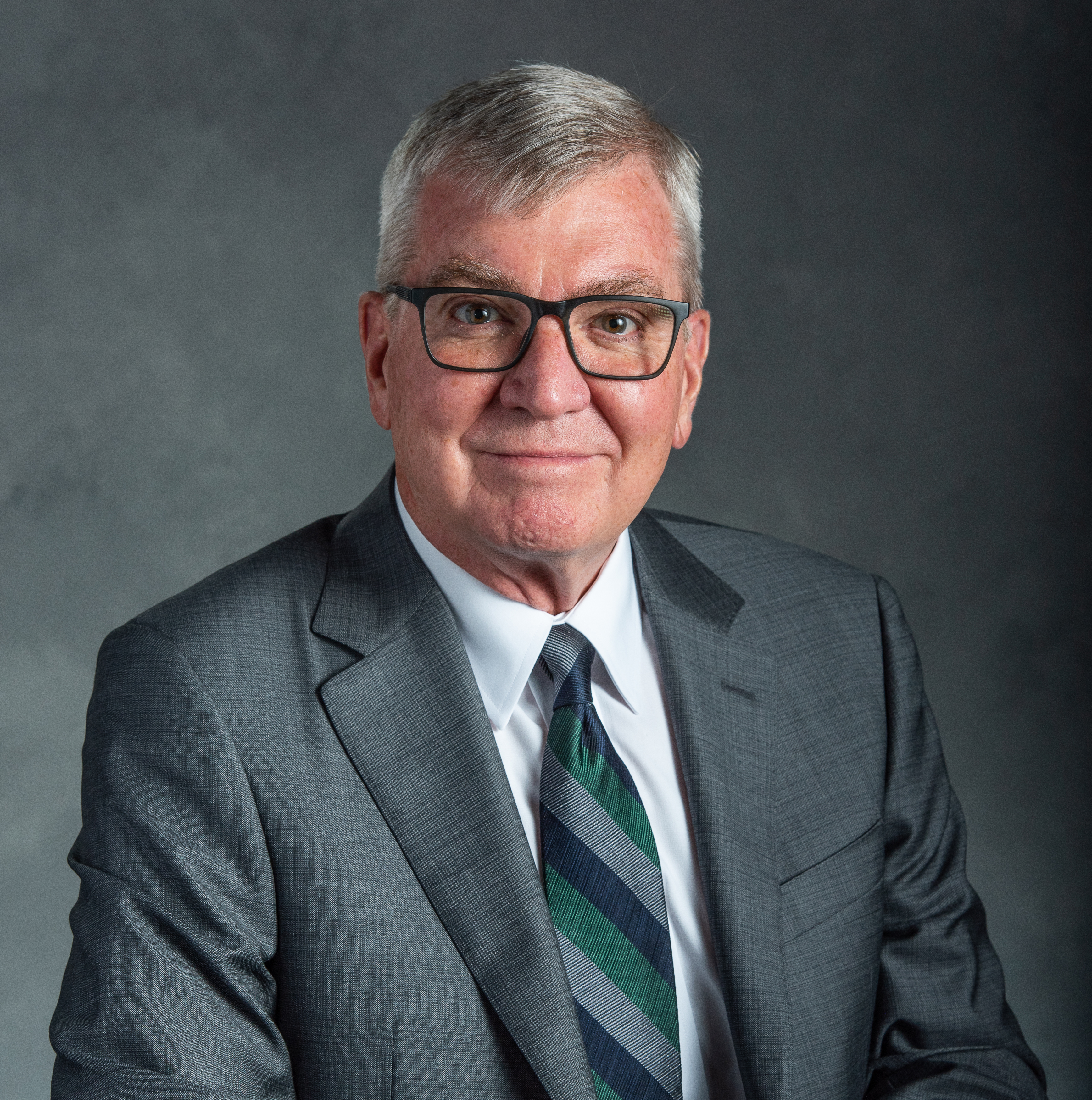 Portrait photo of Doug Gage wearing a suit and tie