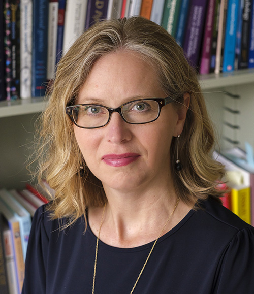 Photo of Alex Burt, a woman with blonde hair and glasses