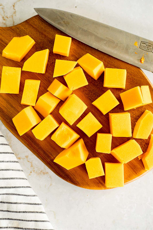 Butternut squash cut into cubes on a cutting board.