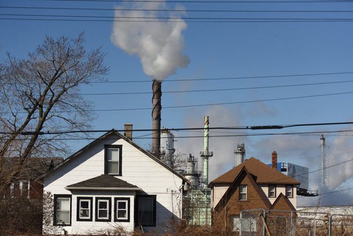 photo of houses with smokestacks in background