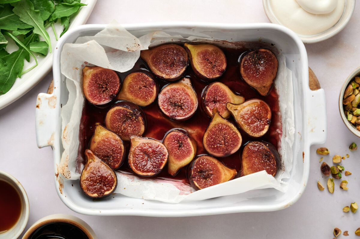 A casserole dish filled with baked figs in their juices.
