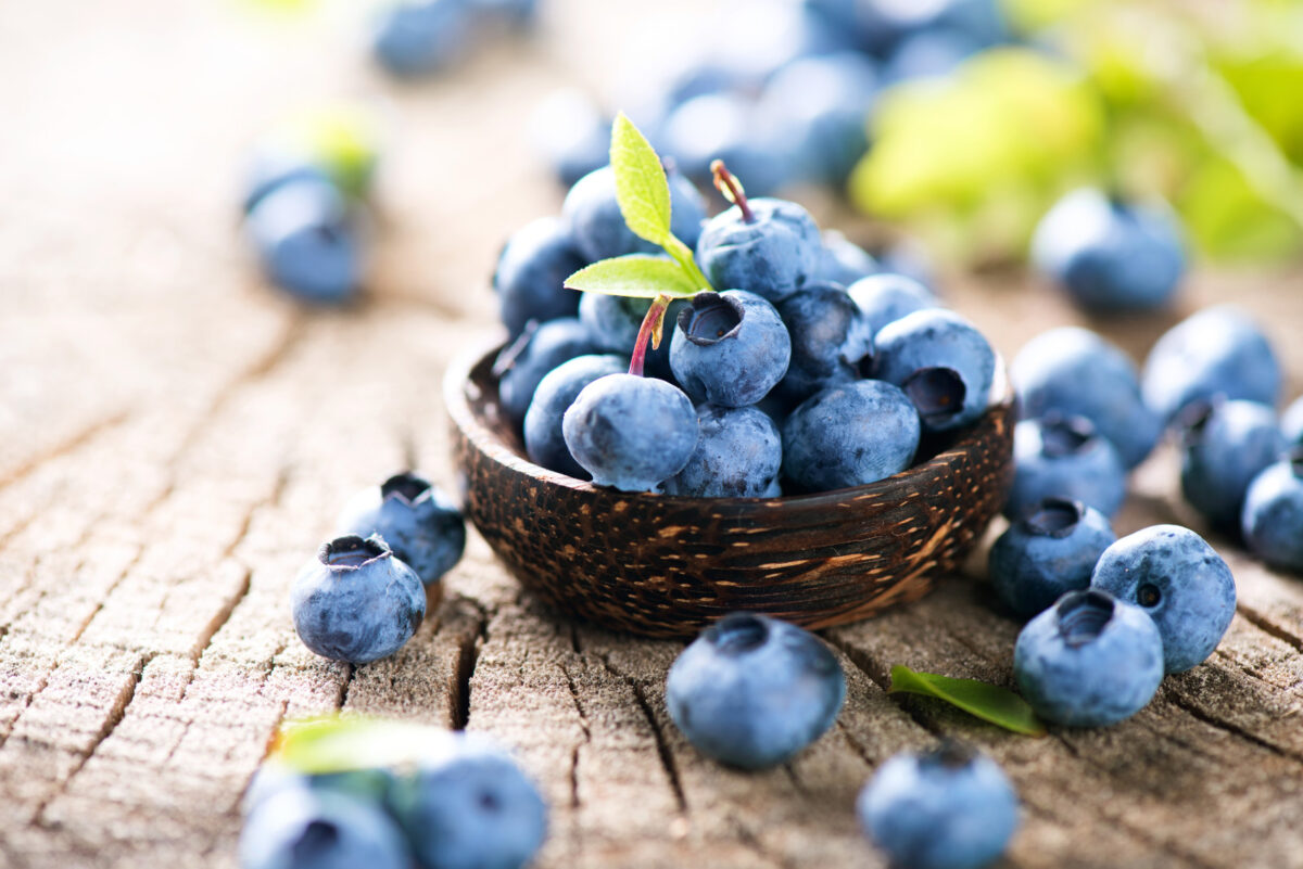 Freshly picked blueberries on top of a wooden surface.