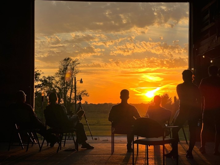 A group of people looking out onto a sunset