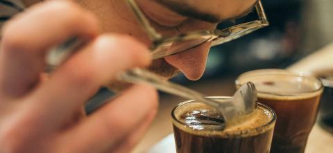 man smelling cup of coffee