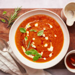 Roasted tomato soup garnished with basil, half and half, and maple syrup.