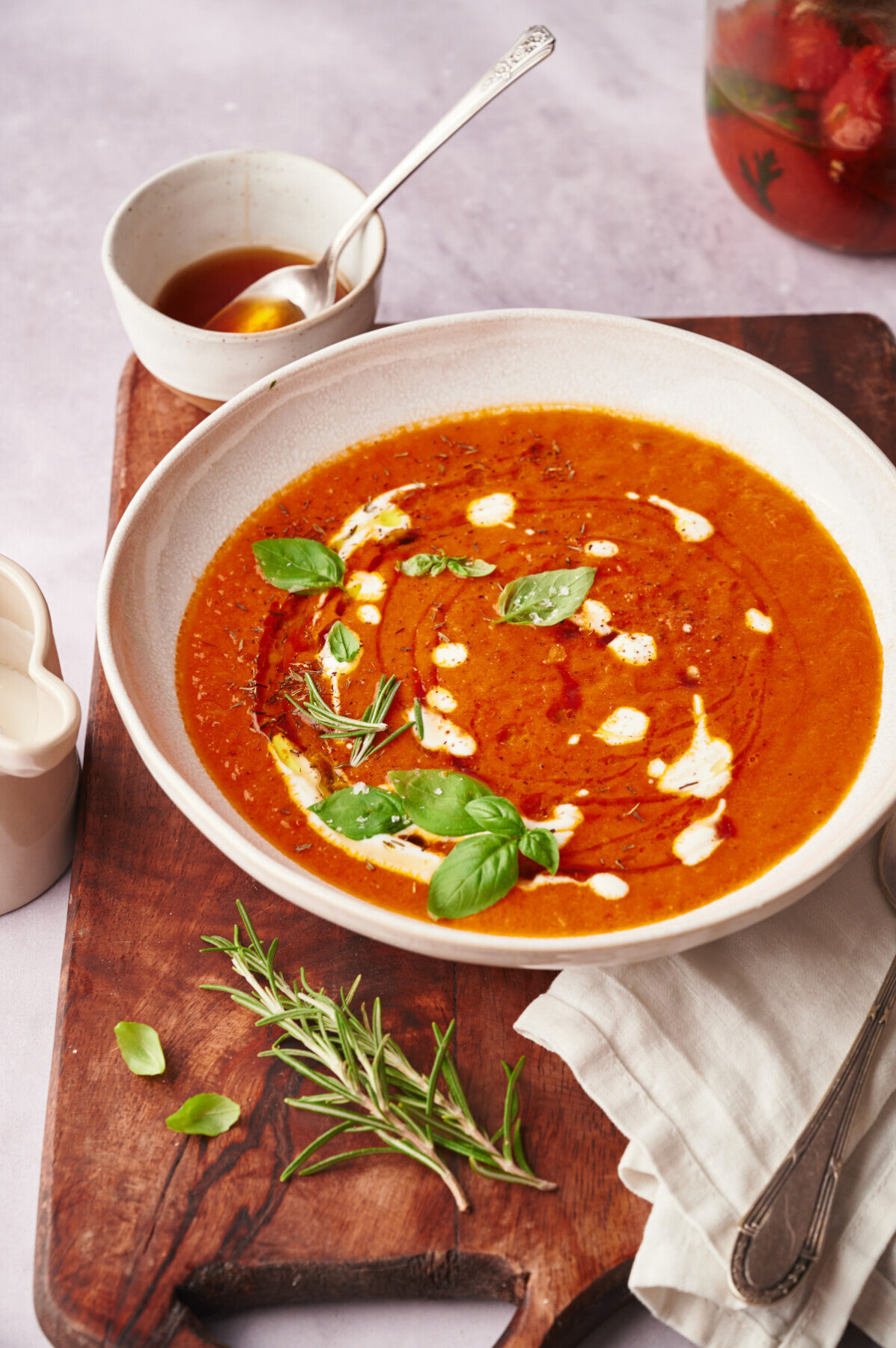 Roasted Tomato Soup in a white bowl on a wooden cutting board.