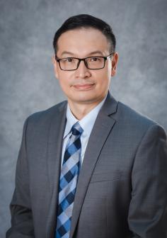 Qingxu "Bill" Jin portrait photo, man with fair complection, dark hair and glasses in suit and tie