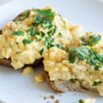 bread with scrambled egg topped with fresh parsley