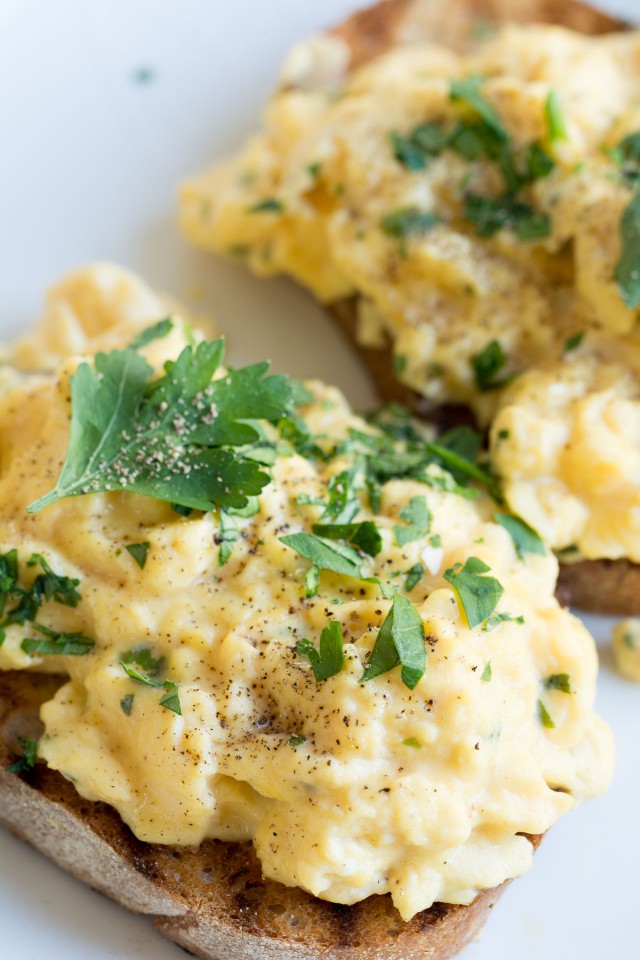 bread with scrambled egg topped with fresh parsley