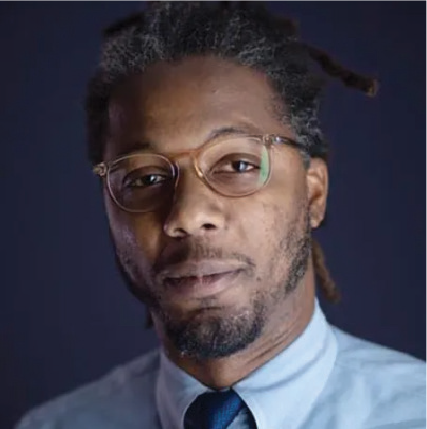 Dwayne Ray Cormier, a man with dark hair, facial hair, glasses, wearing a shirt and tie