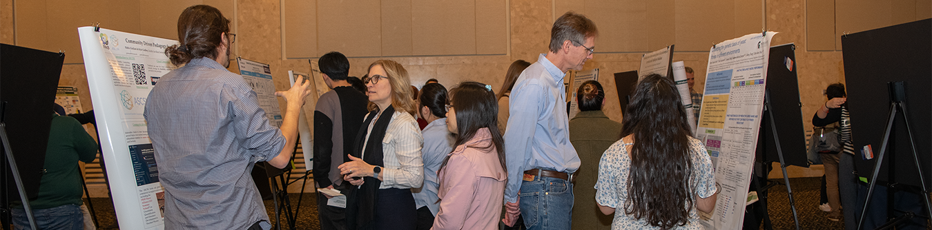 A group of people at a research event, talking to each other. 