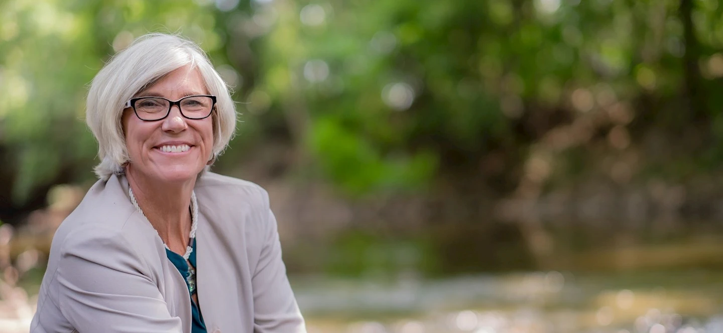 Women with glasses and suit jacket with river in the background